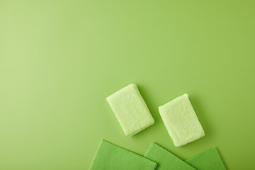 top view of sponges and rags for house cleaning on green