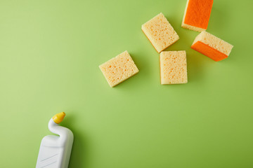 top view of sponges and bottle with toilet cleaner on green