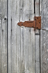 Old wooden not painted background, with rusty metal hinge