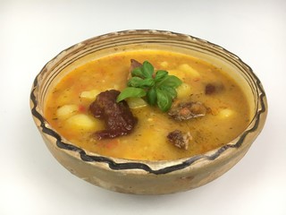 Gulyas traditional Hungarian goulash homemade food in a hand made hand painted clay bowl