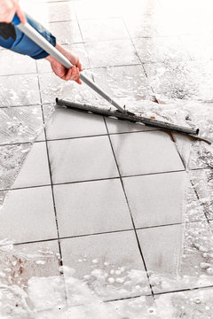 A Man Washes A Tile Floor From Dirt With A Mop And Detergents With Foam.