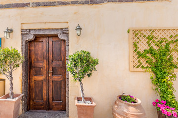 Touristic destination in Greece, urban street photo white vintage old wooden door, flowers, lamp