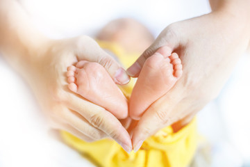 Baby feet in mother hands - hearth shape, Baby feet in mother hands. Mom and her Child. Happy Family concept. Beautiful conceptual image of Maternity.