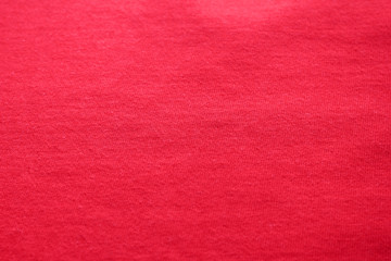 Fototapeta premium Red texture background of cotton fabric detail. Vibrant pink or cherry red colour cloth, empty natural material backdrop of casual plain burgundy color shirt 
