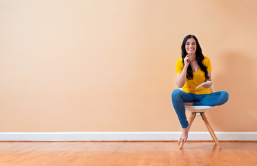 Young woman using her tablet sitting in a chair