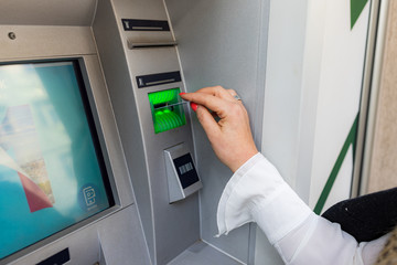 Midle age woman is withdrawing money from ATM machine