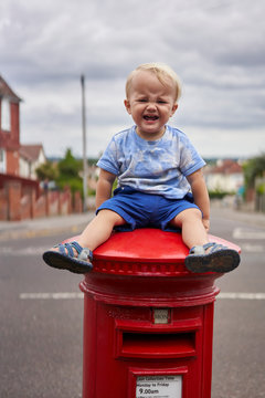 Crying Toddler Sitting On Postbox