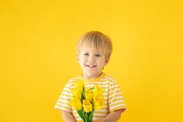 Happy child holding spring bouquet of flowers