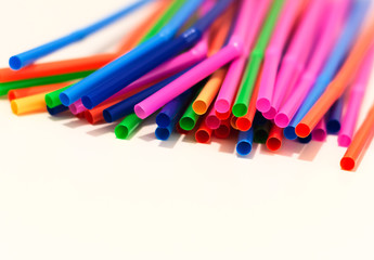 a group of colored plastic cocktail straws. Plastic and non-recyclable materials.