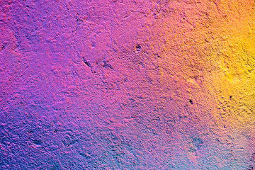Abstract metal texture with a spray can of paint a gradient of yellow, purple and pink.