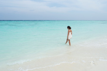 Fototapeta na wymiar Woman walking on the beach