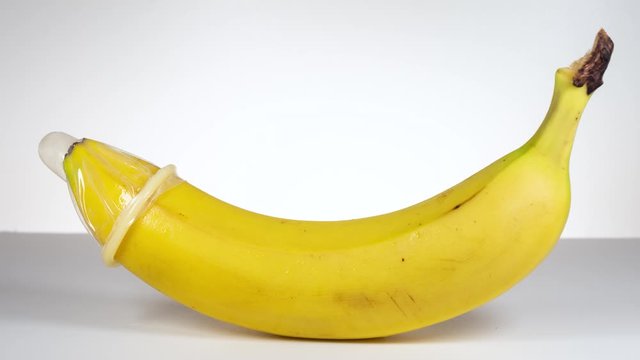 Condom over banana stop motion. Concept for sexually transmitted infections, STD, STI