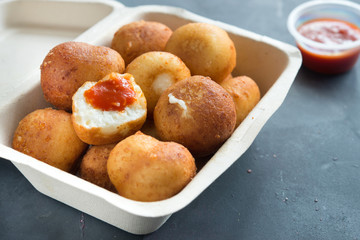 Fried Risotto Arancini stuffed with cheese, served with tomato sauce