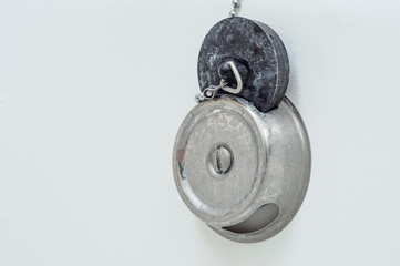A stopper for a bath with a leash lies in its place in the groove. Dirty in white stains.
