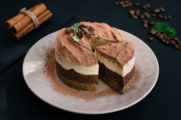  Tiramisu on a beige plate. Coffee with cinnamon. Raw dessert