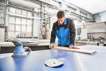 Process of production and manufacture of wooden furniture in furniture factory. Worker carpenter...
