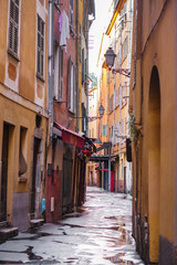 Fototapeta na wymiar Narrow street in Nice, old colorful buildings in the old town, French Riviera