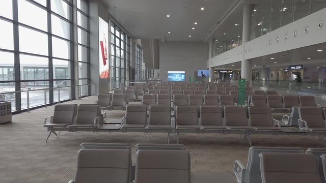 Many seats at empty airport terminal waiting area.  No people in lounge at evacuated airport. Low season means poor business for air travel. Airport abandoned after terrorist attack.