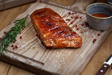 BBQ beef ribs steak served with a hot chili pepper and fresh tomatoes on an old vintage wooden cutting board
