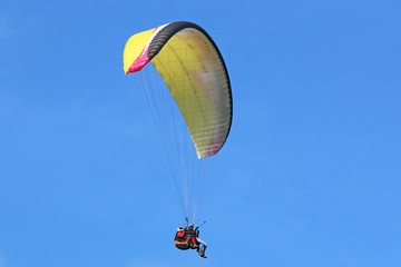 Tandem Paraglider flying wing in a blue sky