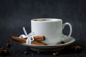 Fruit cake and a cup of coffee on a black table.