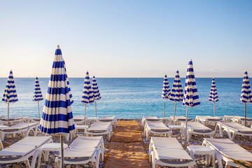 View of the blue striped umbrellas on the beach in Nice, Cote d'Azur, Southern France