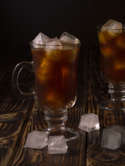 coffee drink with ice in a glass mug on a wooden background.