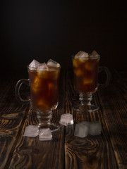 coffee drink with ice in a glass mug on a wooden background.