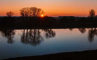 Obraz premium Beautiful sunset with reflections at the river danube near Winzer, Bavaria, Germany