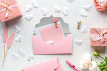 Gift box with ribbon, decorative hearts and flowers on white stone background. Concept of Valentine's, mother's, women's day and birthday greeting.