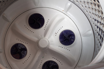 Washing machine interior. White and silver drum.