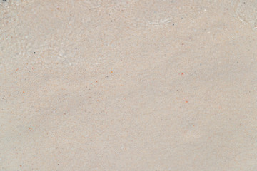 Top view of sea water on the clean white sand from wave ripple