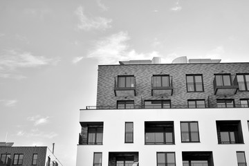 Detail of modern residential flat apartment building exterior. Fragment of new luxury house and home complex. Black and white.