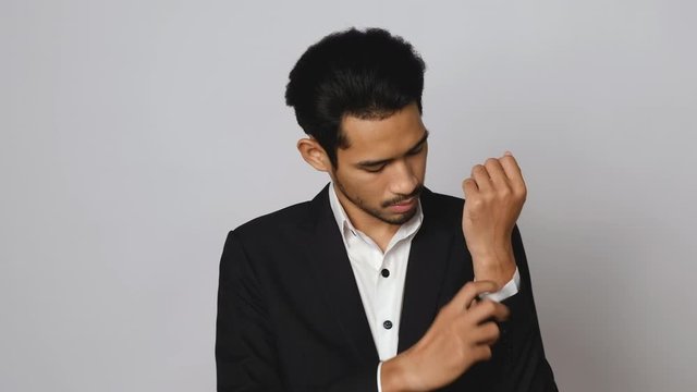 Close-up view of young asian man in formal business suit or groom costume getting dressed preparing for work.