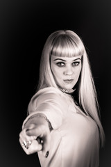 Portrait of a woman on a black background. The woman is blonde, dressed in a light blouse. Shows...