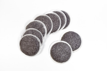 Coffee pads, portioned servings of coffee wrapped in paper filter, on white background