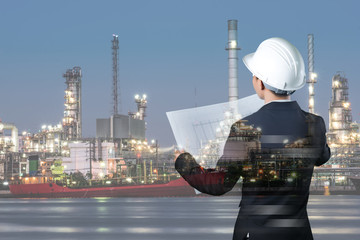 Double exposure of manager and engineer working with safety helmet with oil refinery industry plant background