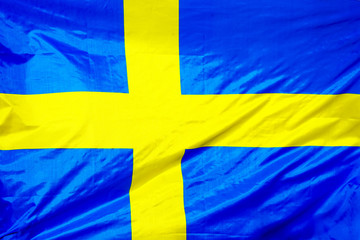 Fabric texture flag of Sweden. Flag of Sweden waving in the wind. Sweden flag is depicted on a sports cloth fabric with many folds. Sport team banner.