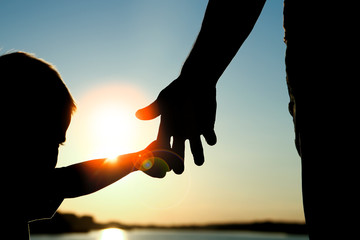 silhouette the parent holds the hand of a child