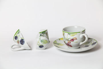 Due tazze da caffè di cui una rotta su sfondo bianco