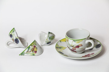 Due tazze da caff&egrave; di cui una rotta su sfondo bianco