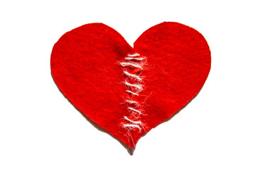 Sewed a broken heart with a thread. Red heart made of felt. Broken love concept. Fixed heart with thread.