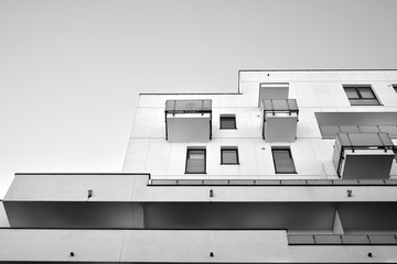 Detail of modern residential flat apartment building exterior. Fragment of new luxury house and home complex. Black and white.