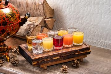Colourful set of alcoholic cocktails in shot glasses shooters on wooden table for an alcoholic party. Set of wine, brandy, liquor, tincture, cognac, whiskey background, toast concept.