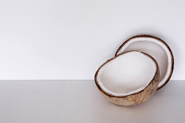 Bright coconut on white background with copy space. Two halves of appetizing coco neutral arrangement. 