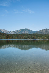 Fototapeta na wymiar Reflejo Montañas y Bosque Simétrico en Alpes Alemania