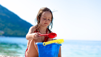Cute little girl is playing by the sea