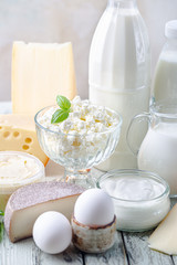 Fresh dairy products, milk, cottage cheese, eggs, yogurt, sour cream and butter on wooden table