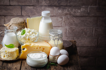 Fresh dairy products, milk, cottage cheese, eggs, yogurt, sour cream and butter on wooden table