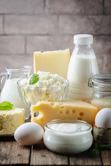 Fresh dairy products, milk, cottage cheese, eggs, yogurt, sour cream and butter on wooden table